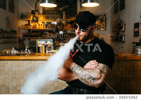 Brutal bearded man in sunglasses smoke an Brutal bearded man in sunglasses smoke an 39855892