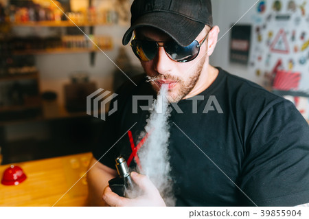 Brutal bearded man in sunglasses smoke an Brutal bearded man in sunglasses smoke an 39855904