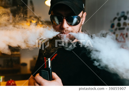 Brutal bearded man in sunglasses smoke an 39855907