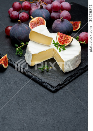 Camembert cheese and cut a slice on stone serving 39856841
