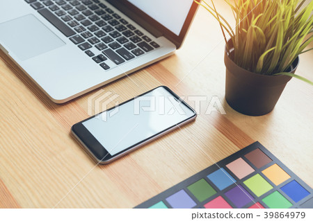 Smartphone and laptop on table in office room. Smartphone and laptop on table in office room. 39864979