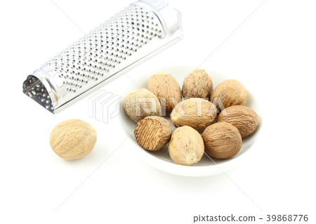 nutmeg seeds in a small white bowl 39868776