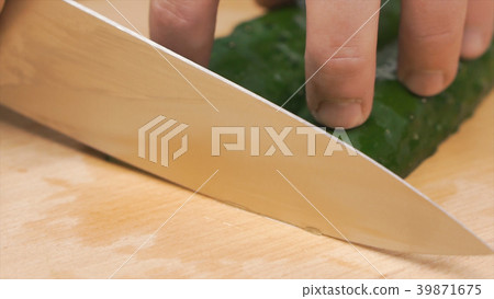 Close-up of hands of chef slicing a cucumber with Close-up of hands of chef slicing a cucumber with 39871675