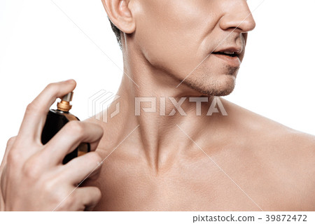 Handsome man using perfume isolated.  39872472