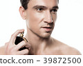 Handsome man using perfume isolated. Beauty man  39872500