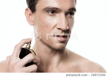 Handsome man using perfume isolated. Beauty man Handsome man using perfume isolated. Beauty man 39872500