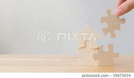 Hand of male or female putting jigsaw puzzle 39873034