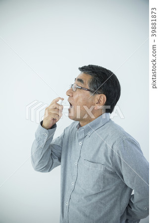 Senior man doing throat spray 39881873