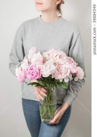 Cute and lovely peony flowers in women's hands Cute and lovely peony flowers in women's hands 39884349