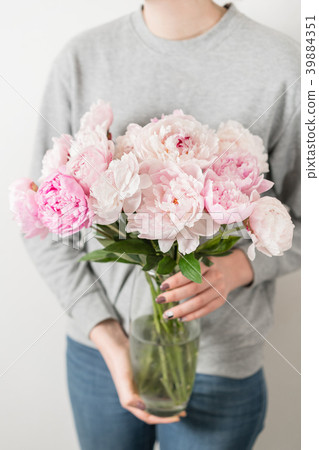 Cute and lovely peony flowers in women's hands Cute and lovely peony flowers in women's hands 39884351