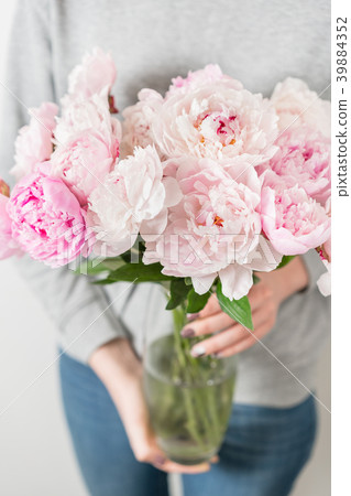 Cute and lovely peony flowers in women's hands Cute and lovely peony flowers in women's hands 39884352