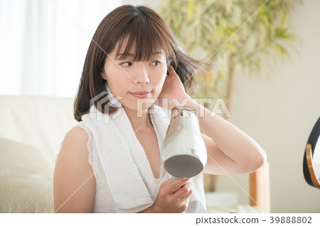 Young Japanese woman drying her hair with a dryer 39888802