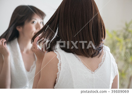 Young Japanese woman drying her hair with a dryer 39889069