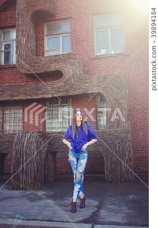 girl stands near the brick wall in blue jeans girl stands near the brick wall in blue jeans 39894184