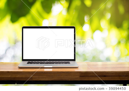Laptop on wooden table in green garden 39894450