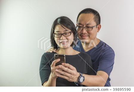 Asian couple reading content on smartphone 39895590
