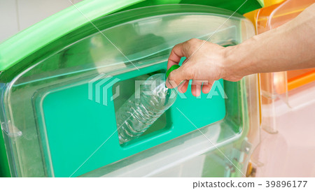 Men trash an empty bottle in a bin. Men trash an empty bottle in a bin. 39896177