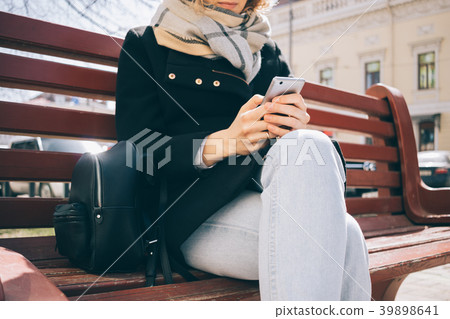 Smiling young woman uses smart phone 39898641