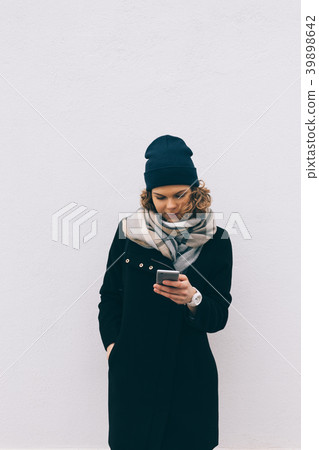 Beautiful hipster girl uses smart phone 39898642
