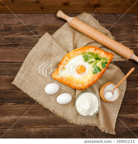 Khachapuri with eggs on sackcloth, salt, flour Khachapuri with eggs on sackcloth, salt, flour 39902213