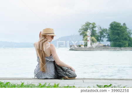 Beautiful girl is sitting on the pier. The sea Beautiful girl is sitting on the pier. The sea 39902258