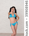 A woman wearing a bikini has various poses and expressions in front of a white background. 39908946