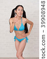A woman wearing a bikini has various poses and expressions in front of a white background. 39908948