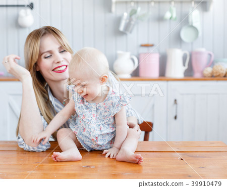 Young mother playing with her baby daughter in a Young mother playing with her baby daughter in a 39910479