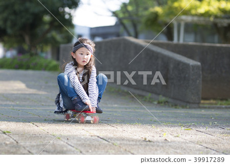 A girl playing on a skateboard A girl playing on a skateboard 39917289