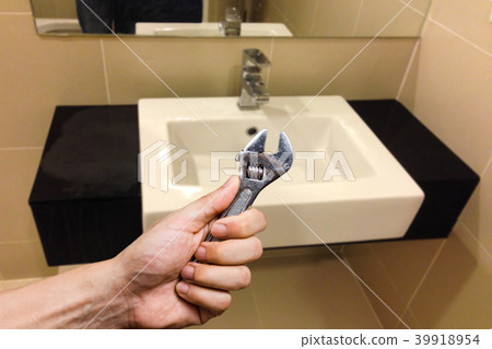 wrench in hand with faucet. home services concept wrench in hand with faucet. home services concept 39918954