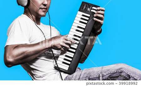 man listening music & playing midi keyboard man listening music & playing midi keyboard 39918992