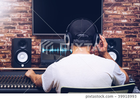 back of sound engineer working in recording studio 39918993