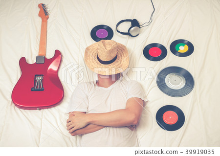man sleeping with guitar, record & headphone 39919035