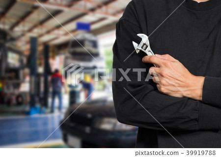 male mechanic holding wrench in car repair shop male mechanic holding wrench in car repair shop 39919788