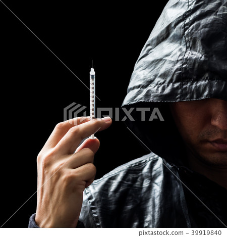 dangerous male drug addict holding syringe in hand 39919840