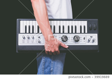 man holding vintage studio keyboard synthesizer man holding vintage studio keyboard synthesizer 39919889