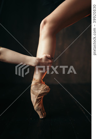 Ballerina hand holds the foot in pointe shoes Ballerina hand holds the foot in pointe shoes 39920830