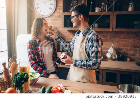 Husband feeds wife a banana on the kitchen Husband feeds wife a banana on the kitchen 39920915