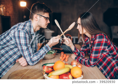 Couple fight with wooden spoons on the kitchen 39920930