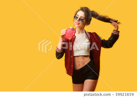Young woman with drinking jar on yellow background Young woman with drinking jar on yellow background 39921659