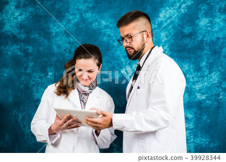 Doctors looking at electronic tablet device Doctors looking at electronic tablet device 39928344