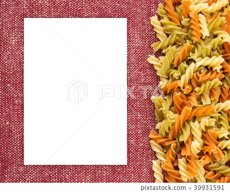Multicolor spiral macaroni Beautiful decomposed pasta with the right, on its side on a rustic red 39931591