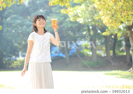 Woman drinking beer in the park Woman drinking beer in the park 39932013