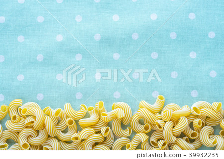 Macaroni rigati Beautiful decomposed pasta from the bottom on a green peas texture. Close-up view Macaroni rigati Beautiful decomposed pasta from the bottom on a green peas texture. Close-up view 39932235