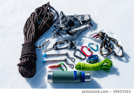 Close-up of winter climbing equipment on fresh snow on a sunny day. Carbines with a rope gazebo and Close-up of winter climbing equipment on fresh snow on a sunny day. Carbines with a rope gazebo and 39933563