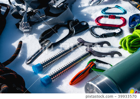 Close-up of winter climbing equipment on fresh snow on a sunny day. Carbines with a rope gazebo and Close-up of winter climbing equipment on fresh snow on a sunny day. Carbines with a rope gazebo and 39933570