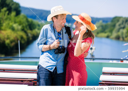 Happy couple on river cruise wearing sun hats 39935994