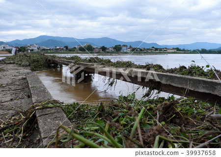 damaged bridge across flowing river 39937658