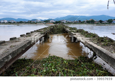 damaged bridge across flowing river 39937659