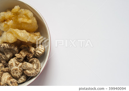Some dried fish Maw and mushrooms in a bowl. 39940094
